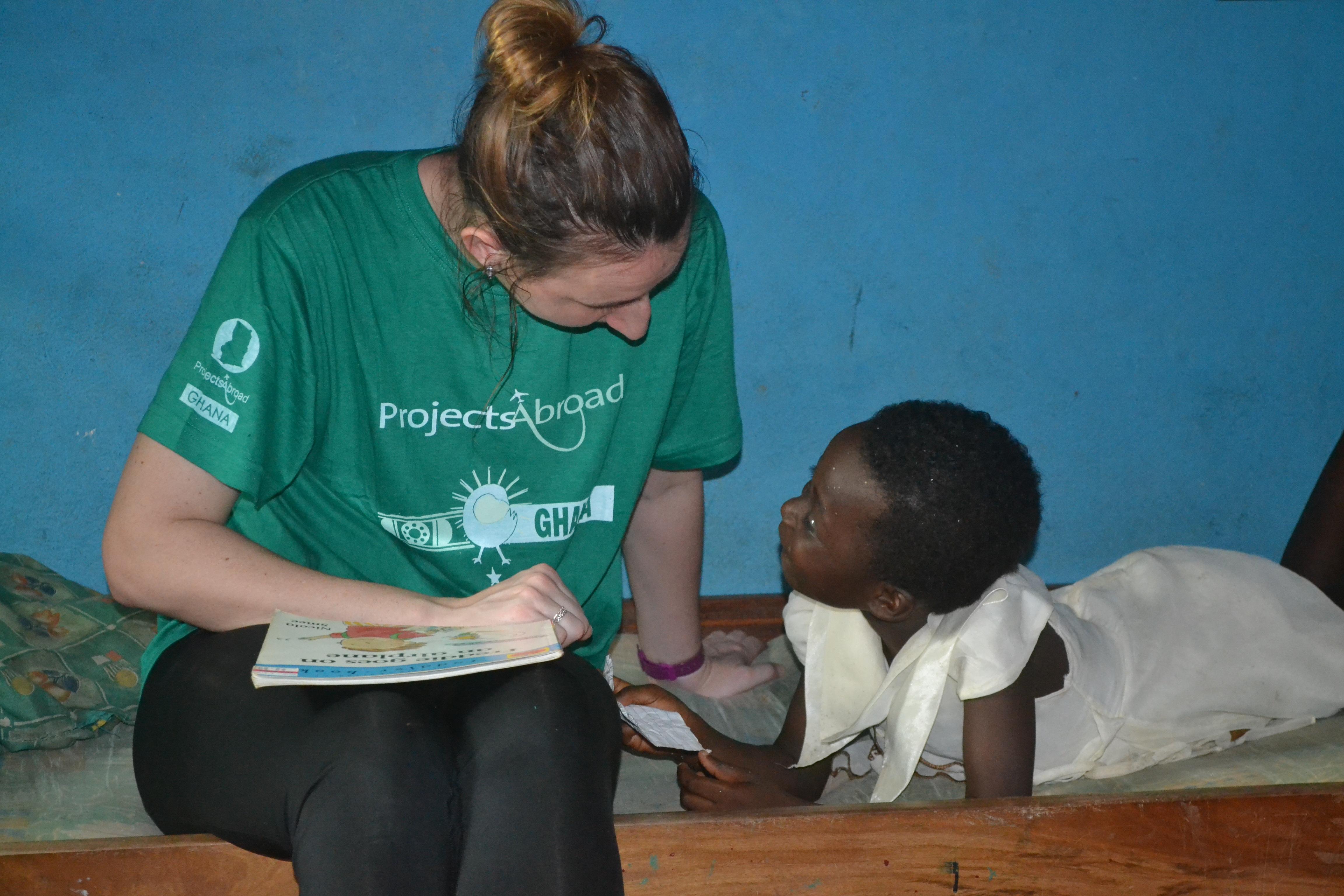 Interna y niña leyendo en una actividad durante nuestras Prácticas de Trabajo Social. Una interna orientando a una niña durante sus Prácticas de Trabajo Social en Ghana.
